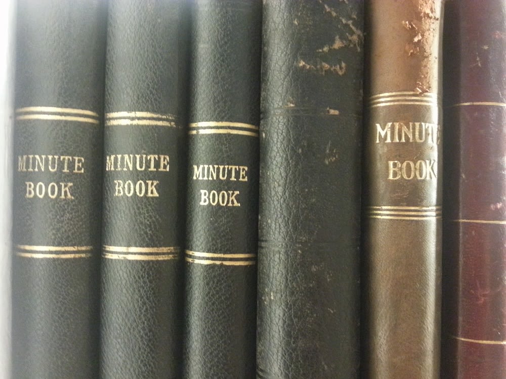 Photograph of the spines of bound minutes books. They are embossed on the side.