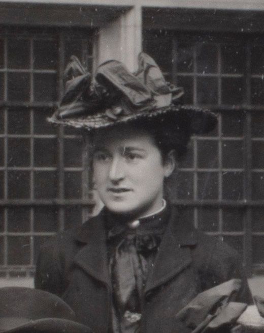 Formal photograph of woman outside. She is wearing a large hat.